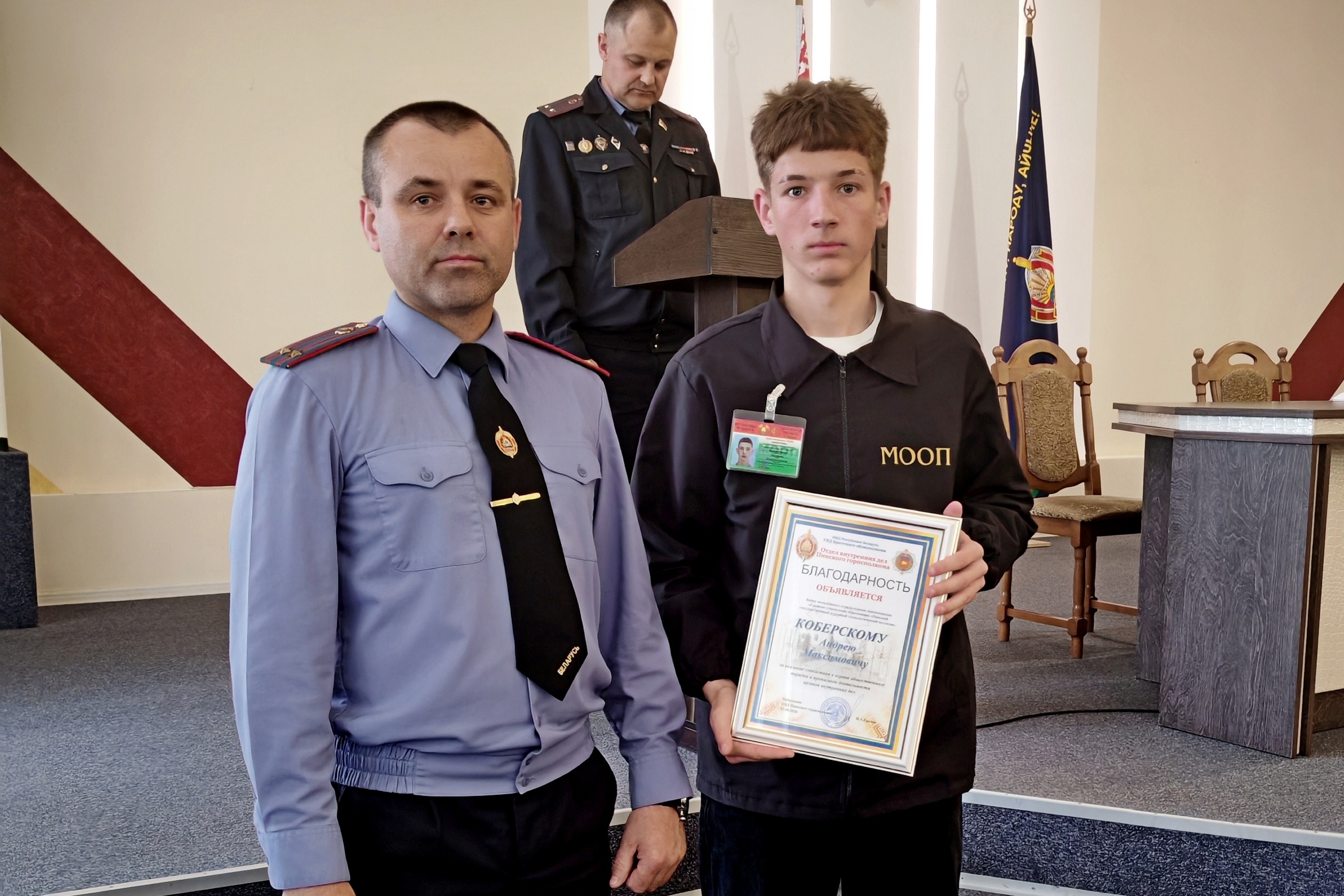 Начальник Пинского ГОВД вручает награду и грамоту молодому бойцу отряда охраны правопорядка