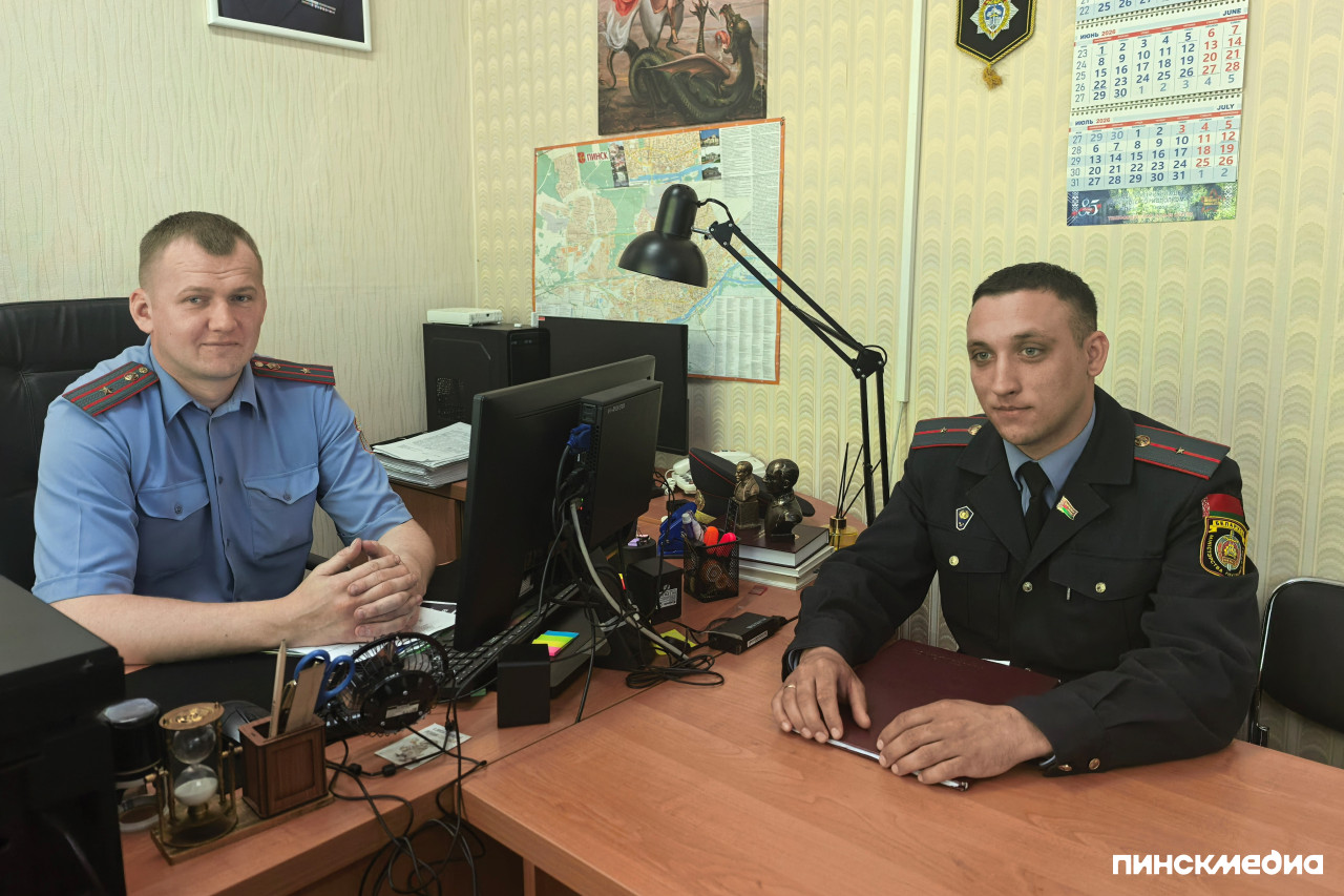 Начальник ИДН Юрий Дорох и инспектор Владислав Ключиц в милицейской форме за рабочими столами в служебном кабинете Пинского ГОВД