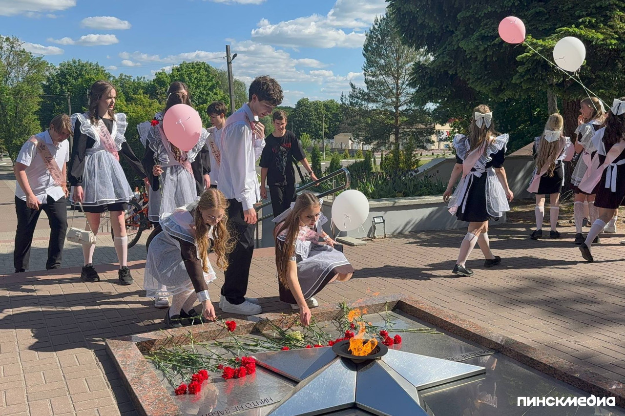 Юноши и девушки возлагают цветы к Вечному огню в Пинске в день Последнего звонка.